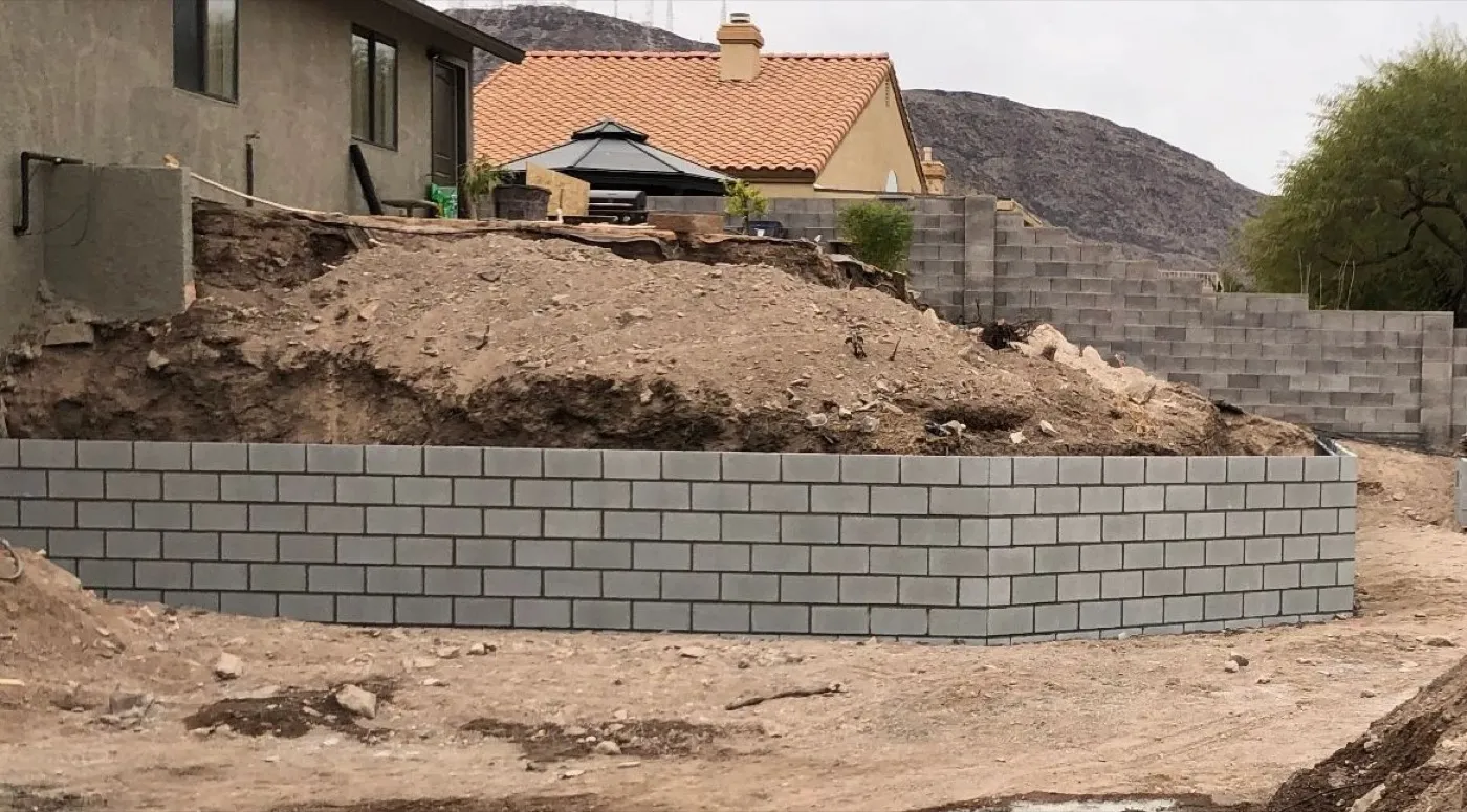 Curved block retaining wall holding a graded slope
