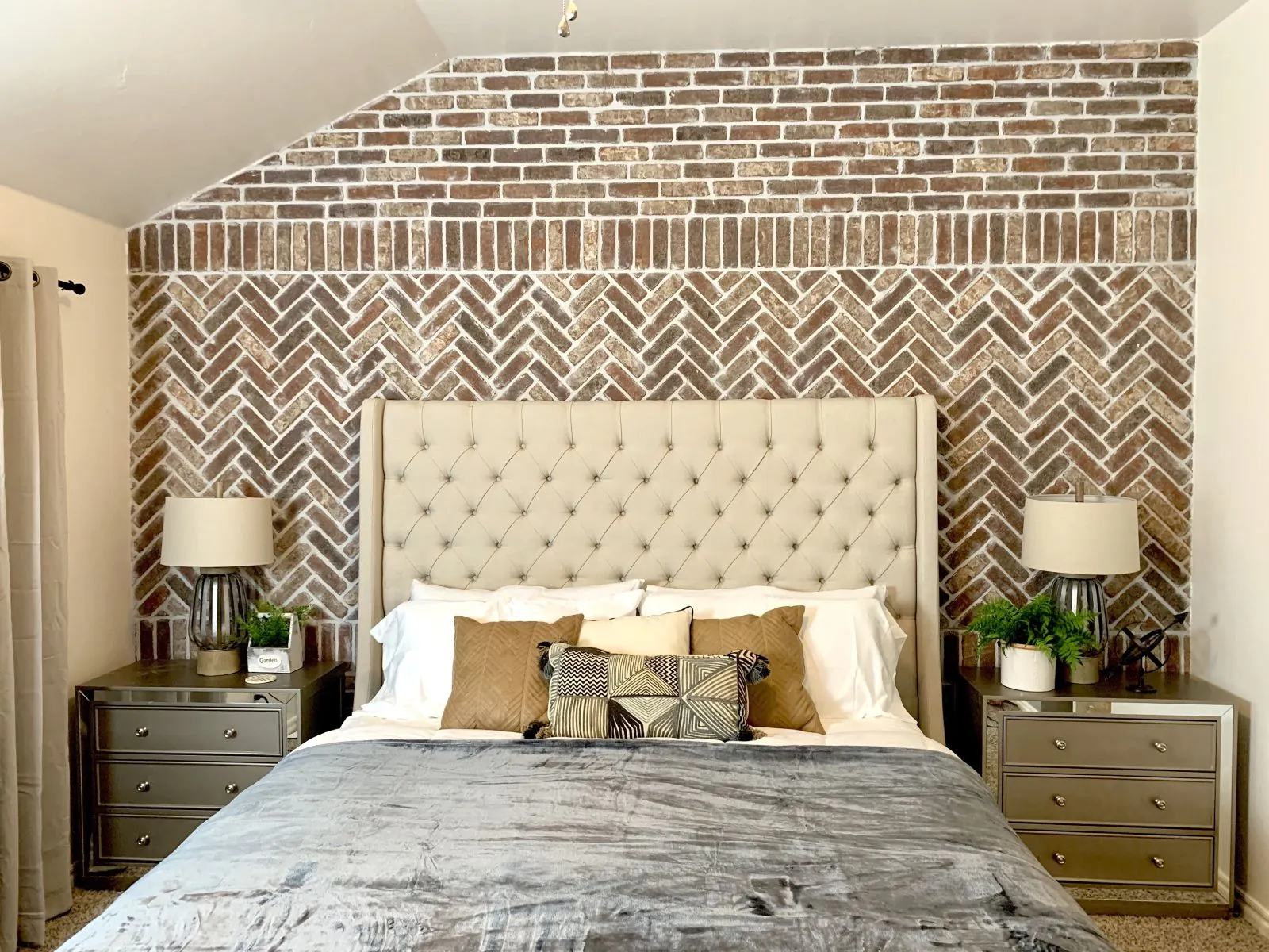 Thin brick accent wall with a herringbone panel behind a bed