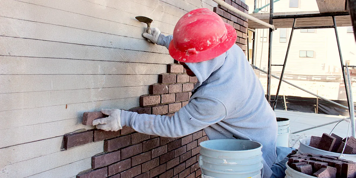 Thin brick being set piece by piece on an exterior wall