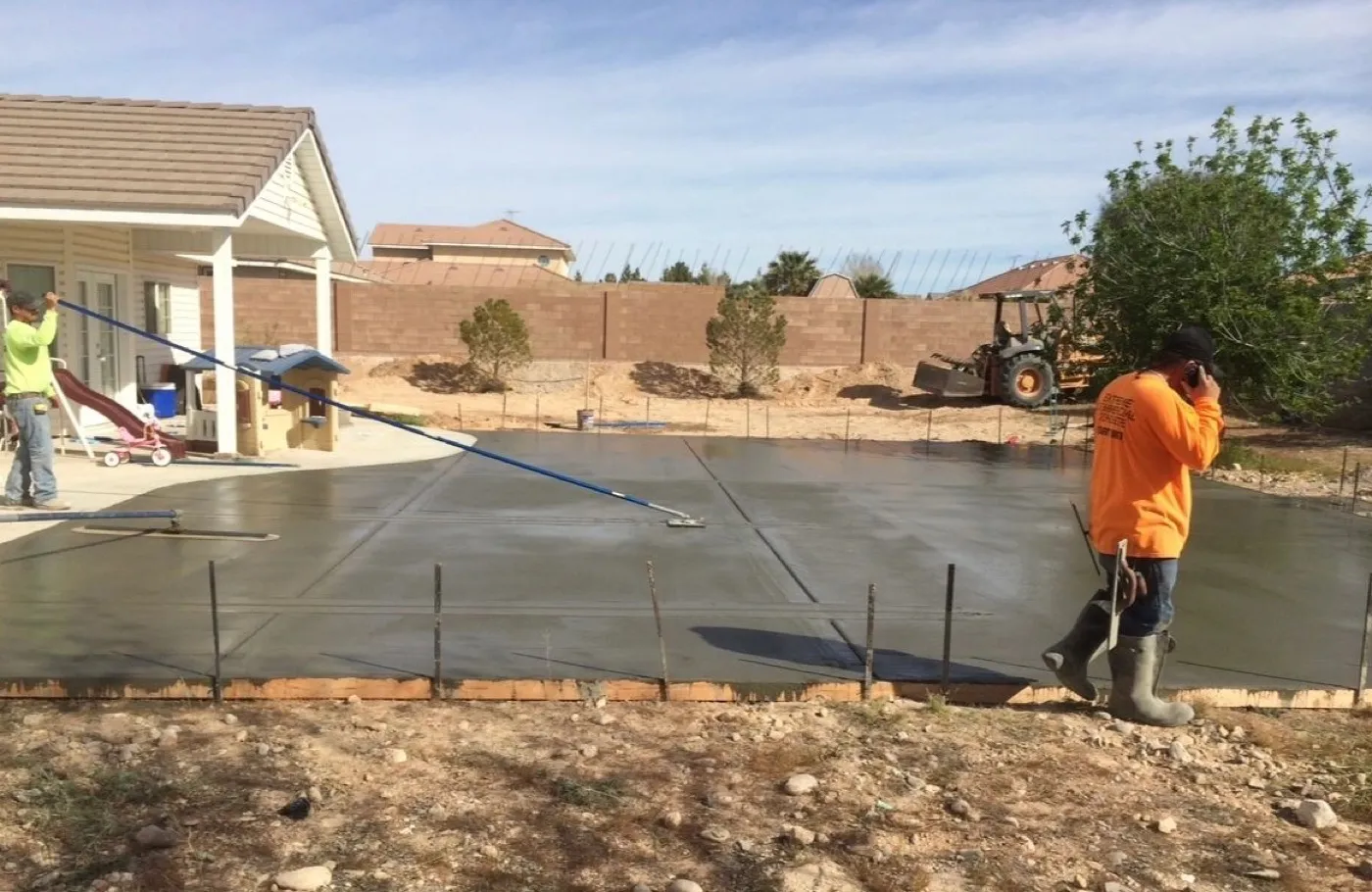 Crew placing concrete with a pump in a backyard