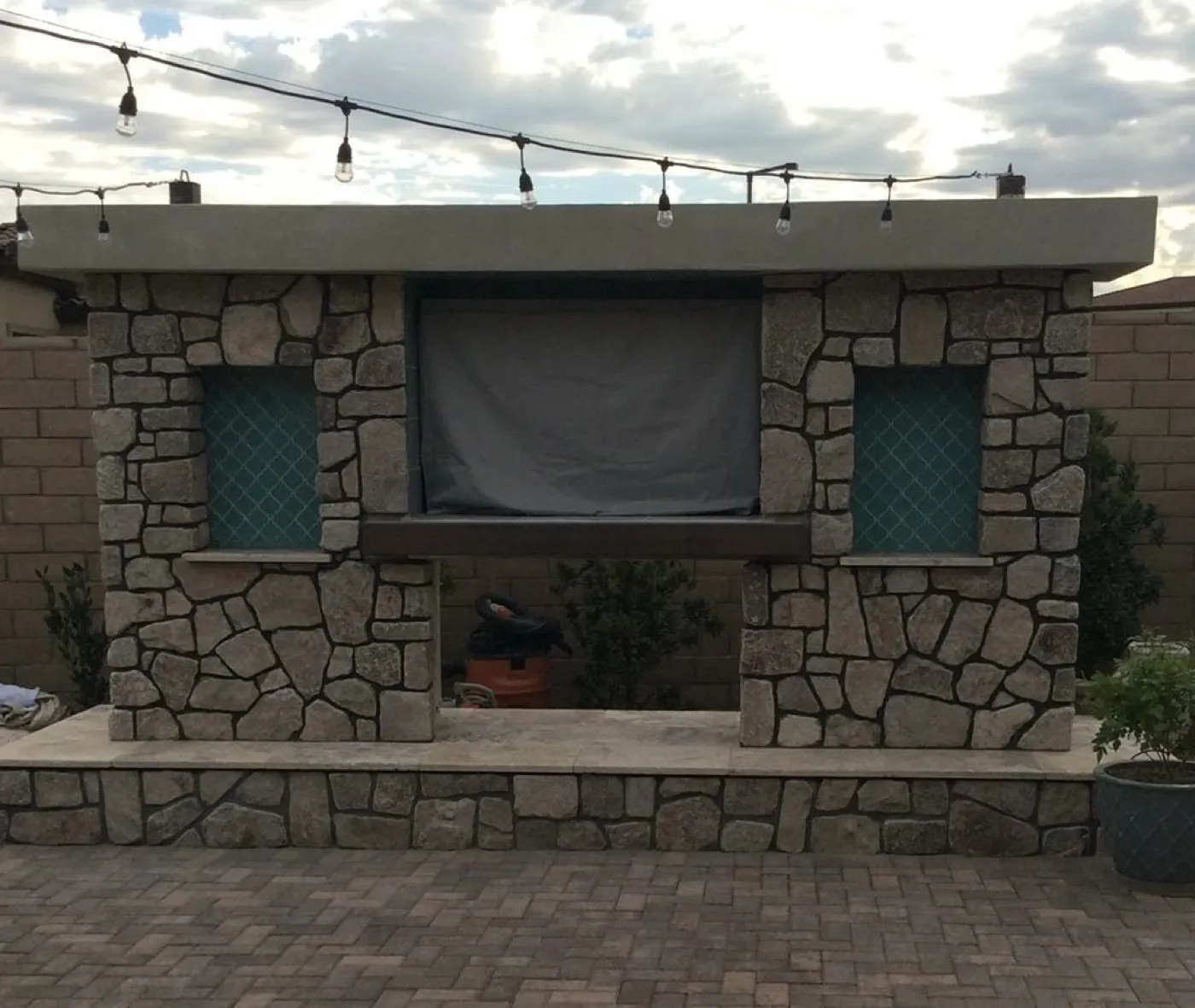 Outdoor stone media wall with covered screen