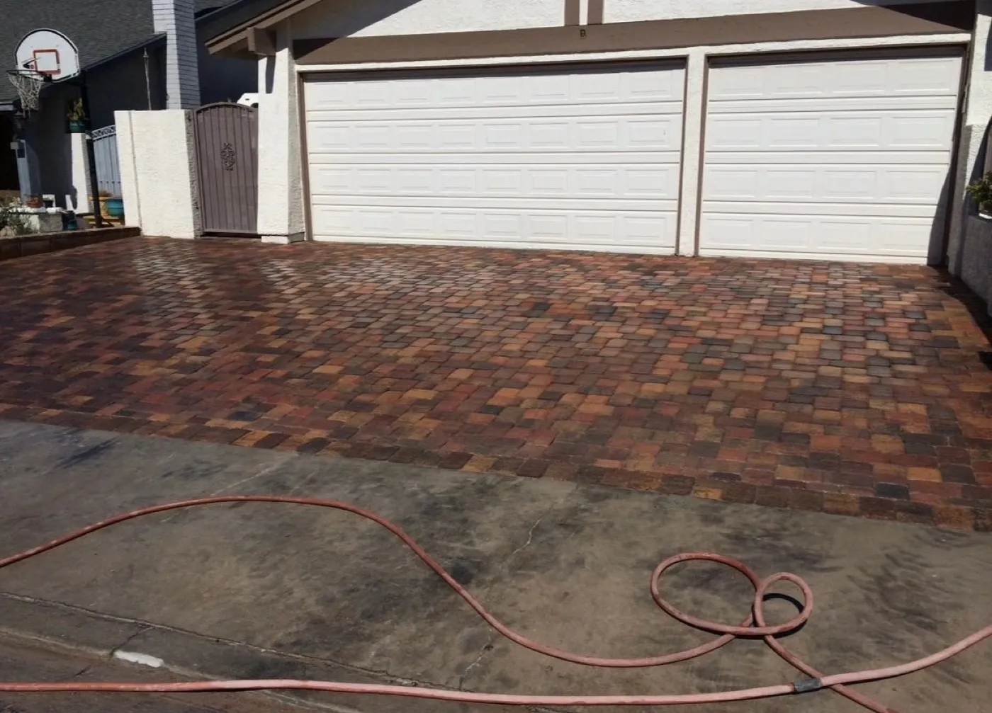 Red paver driveway laid in front of a garage