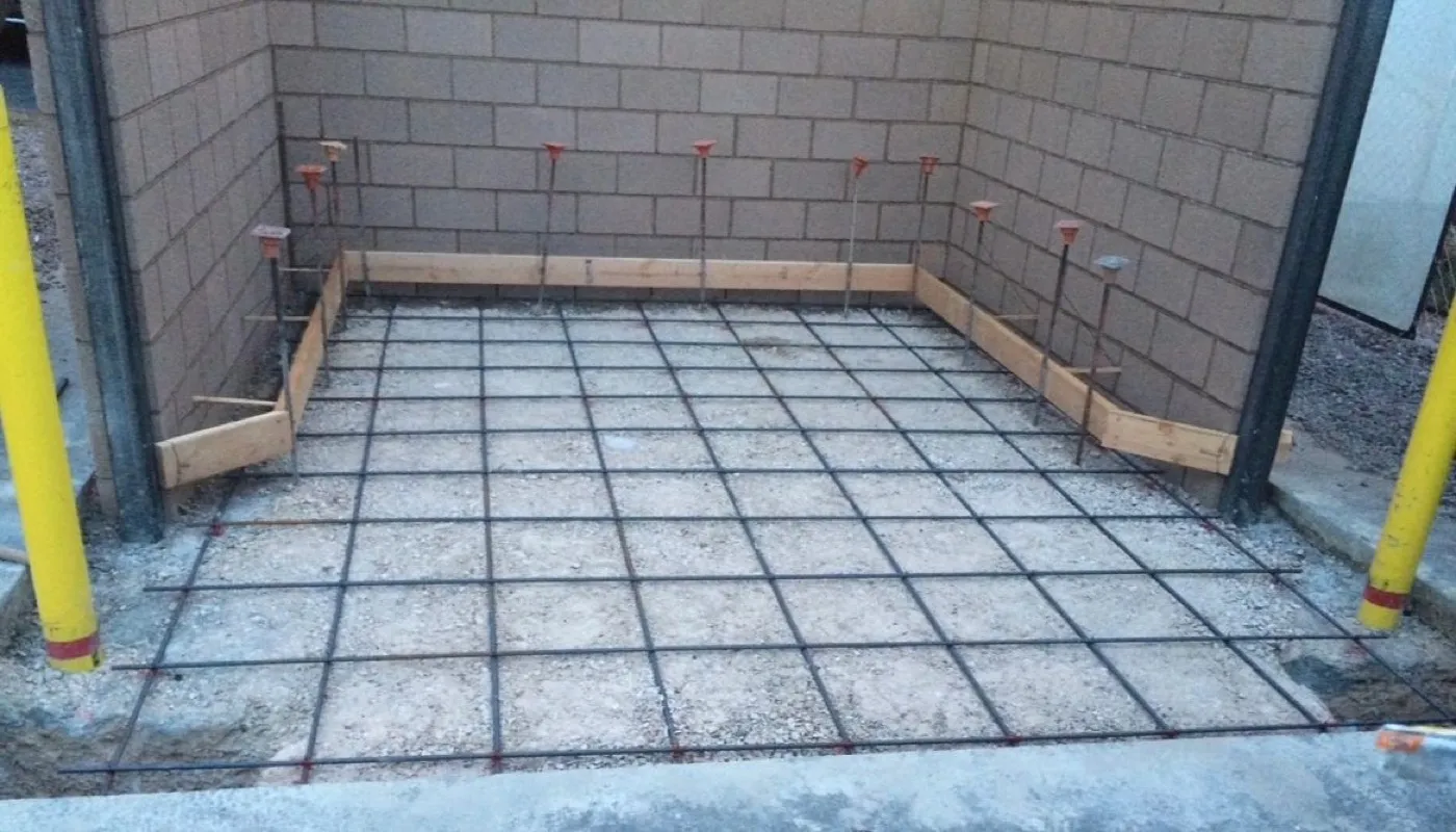 Rebar set on a prepped slab base inside a block enclosure