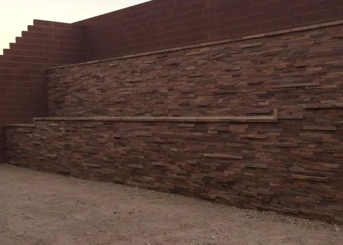 Stone faced retaining planter wall along a yard edge